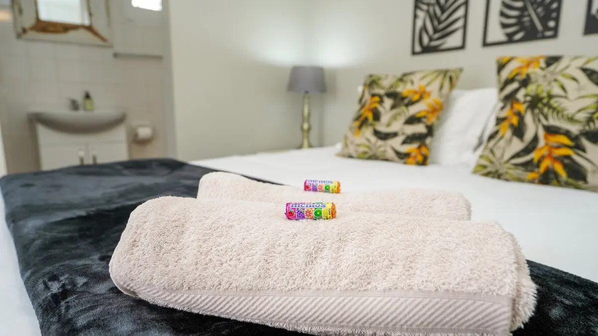 Frische Handtücher und eine kleine Willkommensgeste auf dem Bett