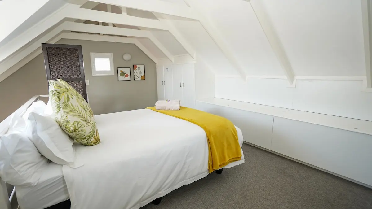 Doppelbett im Obergeschoss unter den offenen Dachbalken