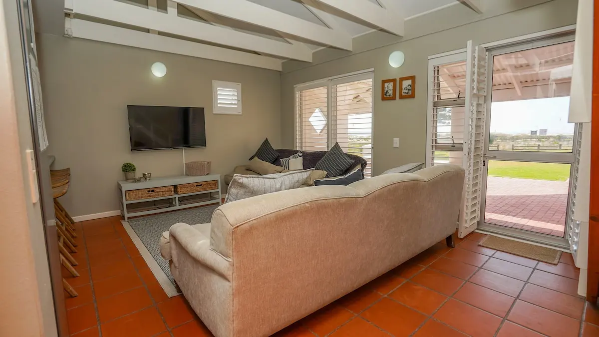 Die Lounge aus einem anderen Blickwinkel, mit weit geöffneten Türen zum Garten